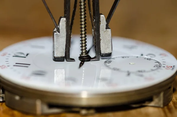 Watch Repair: Hands Remover About to Lift The Hands from a Pocket Watch Movement