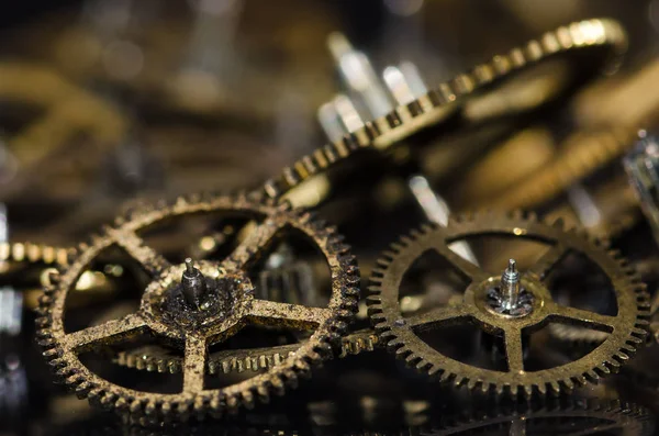 Watch Parts: Dirty and Grimy Vintage Metallic Watch Gears on a Black Surface