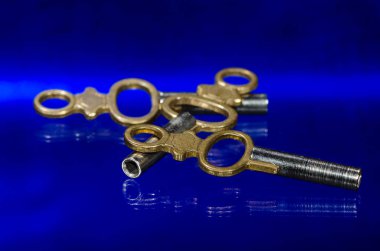 Üç antika pirinç cep saati anahtar üzerinde mavi yüzey döşeme 