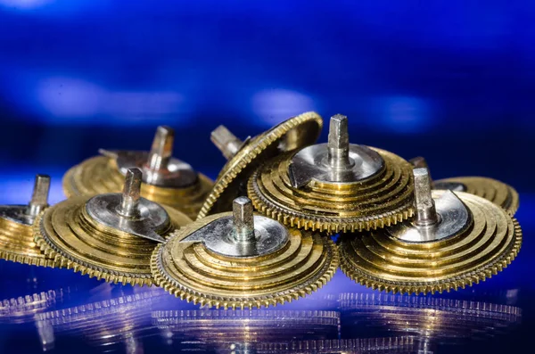 Watch Repair: Vintage Pocket Watch Fusee Cones Resting on a Blue Surface