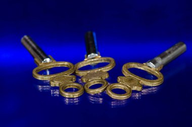 Üç antika pirinç cep saati anahtar üzerinde mavi yüzey döşeme 