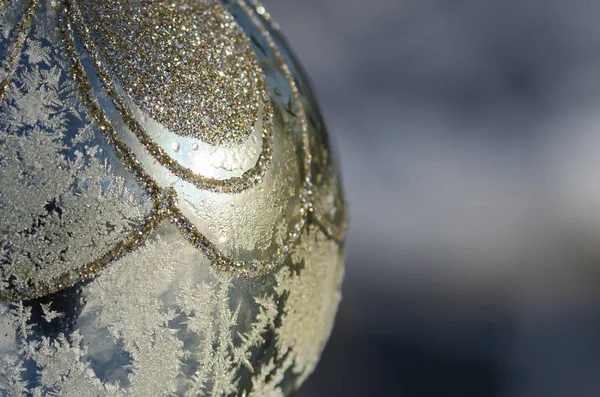 Mira de cerca un adorno de Navidad al aire libre congelado de oro — Foto de Stock