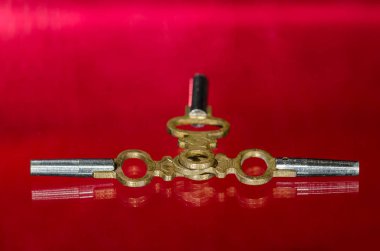 Üç antika pirinç cep saati anahtar üzerinde kırmızı yüzey döşeme 