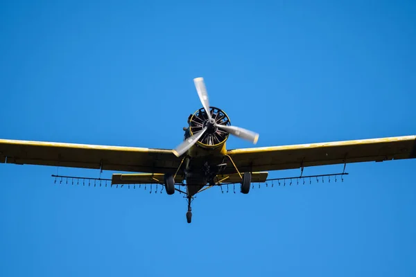 Yellow Crop Dusting Plane Flying in a Blue Sky