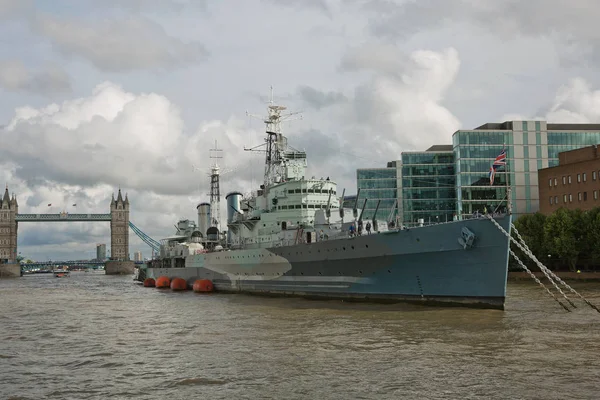 HMS Belfast war ship on the Thames river with the Tower bridge in the background. Stock Picture