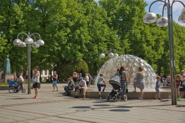 İnsanlar Oslo, Norveç 'teki parkta güneşli bir yaz gününün tadını çıkarıyorlar.