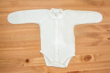 Ahşap arka plan üzerinde yeni doğan kız için giyim