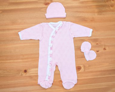 Ahşap arka plan üzerinde yeni doğan kız için giyim