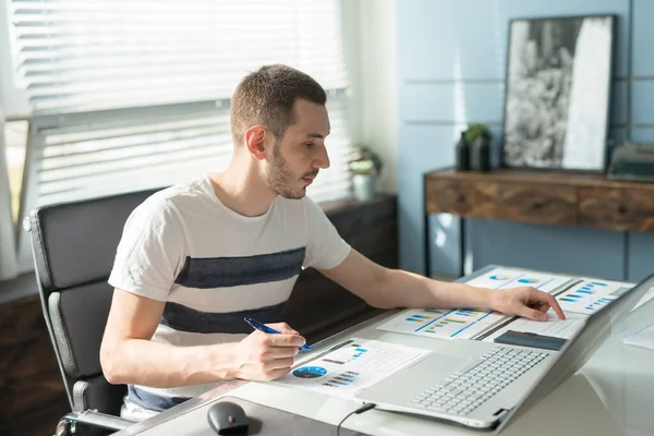 Junger Geschäftsmann arbeitet an einem Laptop an seinem Schreibtisch im Büro — Stockfoto