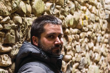 Sakallı adam kameraya güzel bir yüzle bakıyor.