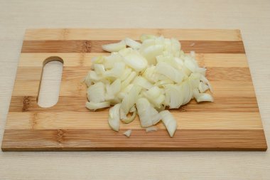 Ahşap kesme tahtası üzerinde dilimlenmiş soğan
