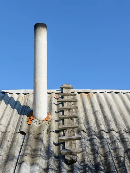 Atap tua batu tulis dari cerobong asap pada latar belakang langit biru — Stok Foto