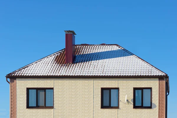 Chalet sur le toit avec neige contre le ciel bleu — Photo