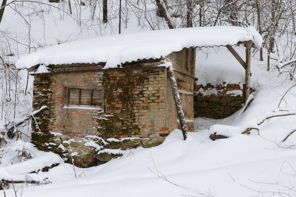 crumbling cabin in a winter snow-covered forest