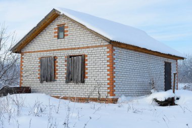 Karla kaplı bir alanda terk edilmiş tamamlanmamış tuğla ev