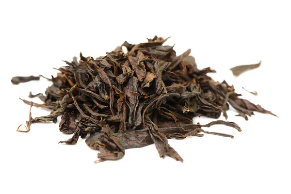 Manciata di foglie secche di tè nero su uno sfondo bianco — Foto Stock