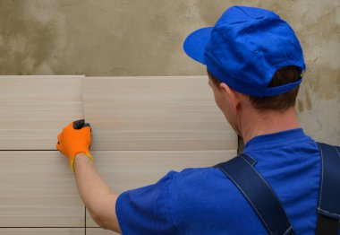 Tulum yöneticisinde Seramik karo duvara koyar.