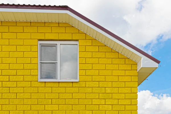 Pared amarilla pintada de bloques con ventana — Foto de Stock