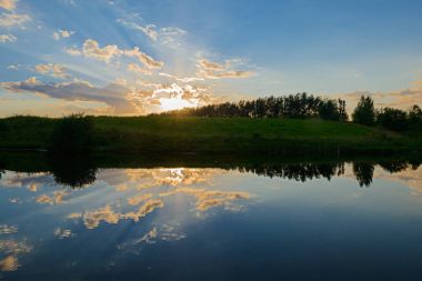 günbatımı gökyüzünün yansıması ile bir su birikintisi içinde ışınları ile