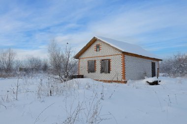 Kış karla kaplı bir alanda bitmemiş tuğla ev