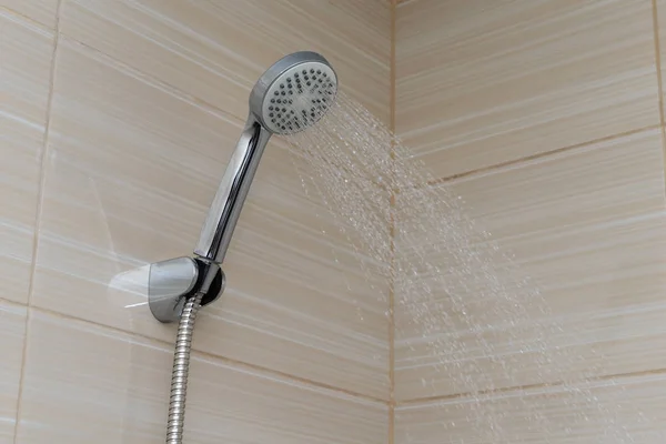 Agua vierte desde el follaje de la ducha en el baño — Foto de Stock