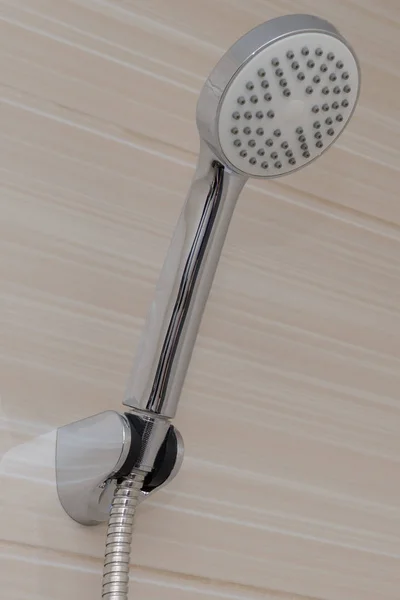 Duschkopf auf beigefarbenen Fliesen im Badezimmer — Stockfoto