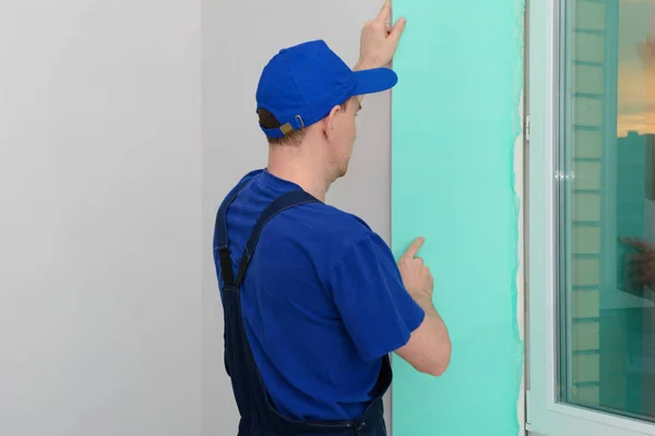 Worker installs sandwich panels for slopes of plastic windows — Stock Image Worker installs sandwich panels for slopes of plastic windows Stock Photo
