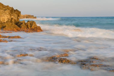 deniz kıyısı dalgalar ve uçurumları ile uzun pozlama üzerinde gün batımında soluk