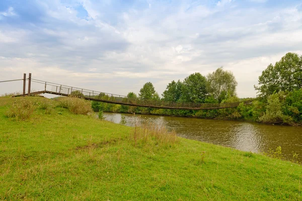 Schorsbrug over de rivier op een bewolkte zomerdag — Stockfoto