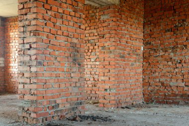 Bitmemiş eski bir odanın içinde tuğla duvarlar