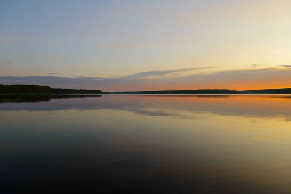 Paysage estival en soirée avec un lac et une forêt à l'horizon — Photo