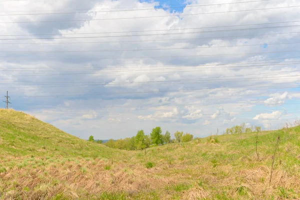 Landskap med gräs i en ravin och kraftledningar mot himlen — Stockfoto