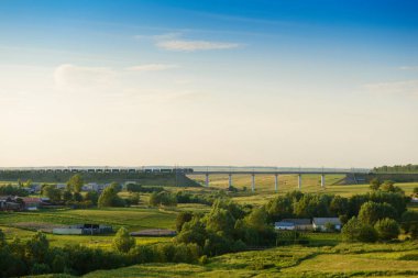 Ufukta demiryolu köprüsü olan yaz manzarası
