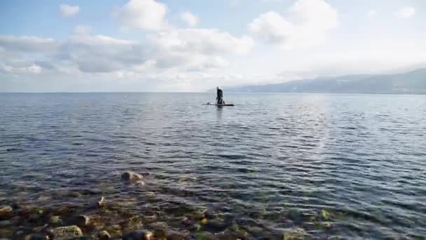 La chica flota en el tablero de la savia en el lago de invierno en Siberia — Vídeos de Stock