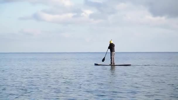 La fille flotte sur la planche de sève sur le lac d'hiver en Sibérie — Video