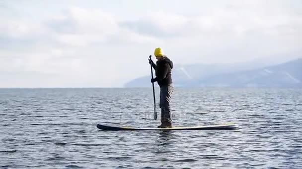 Het meisje drijft op sap bord op winter meer in Siberië — Stockvideo