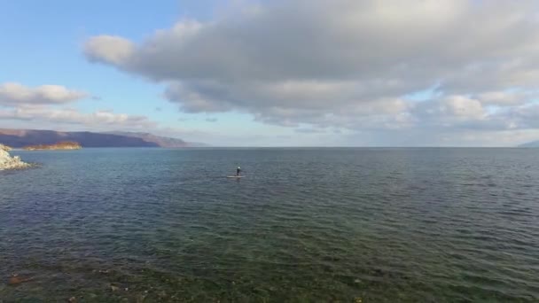 4k. Aero. das Mädchen schwimmt auf einem Saftbrett auf einem Wintersee in Sibirien — Stockvideo