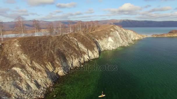 4K. Aero. La ragazza galleggia su asse di linfa su lago invernale in Siberia — Video Stock