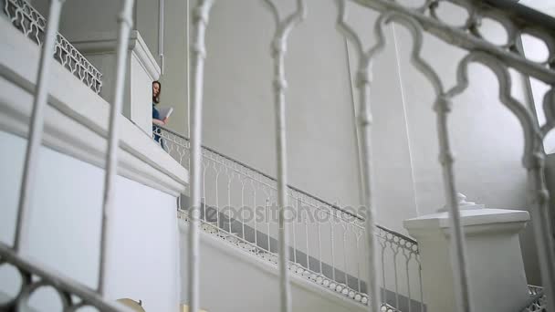 Prores. Menina em vestido azul com documentos desce as escadas — Vídeo de Stock