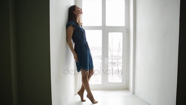 Prores. Chica joven en vestido azul posando en la ventana — Vídeos de Stock