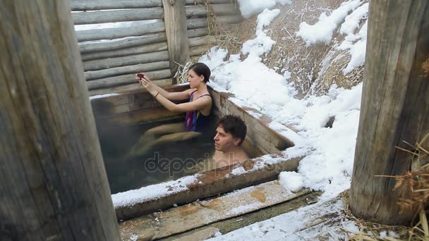 ProRes codec. Een man en een meisje Neem een bad van warme natuurlijke minerale bronnen in de open in de winter — Stockvideo