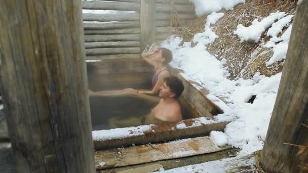 Códec de Prores. Un hombre y una niña toman un baño de aguas termales naturales al aire libre en invierno — Vídeo de stock