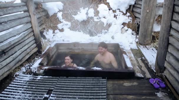Kodek ProRes. Człowiek i dziewczyna wziąć kąpiel gorąca naturalnych źródeł mineralnych w otwartym w zimie — Wideo stockowe