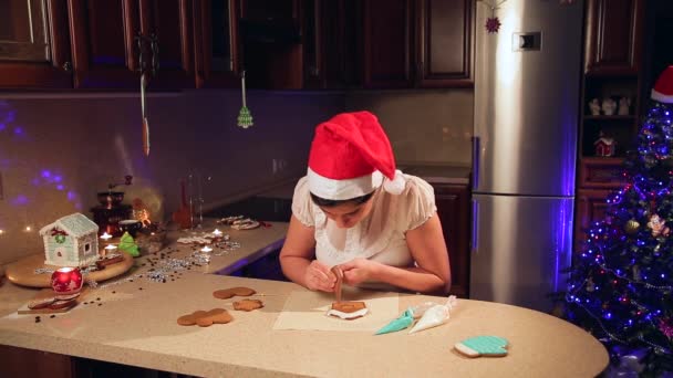 Een meisje bereidt cookies voor Kerstmis in de keuken — Stockvideo