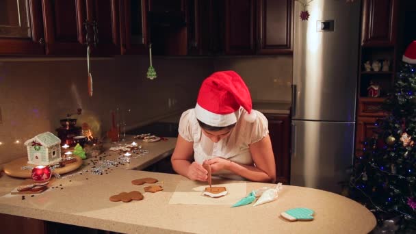 Een meisje bereidt cookies voor Kerstmis in de keuken — Stockvideo