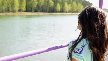 Yaz. Bir kız nehir körfezde iskele yürüyor