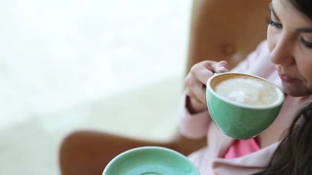 若い女の子がカフェでコーヒーを飲む — ストック動画
