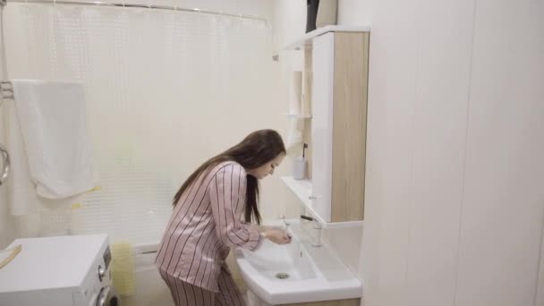 Pembe Gecelikli Uzun Siyah Saçlı Genç Kız Banyoda Dişlerini Fırçalarken — Stok video