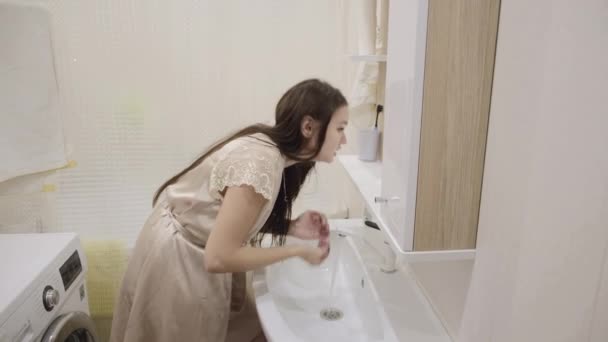 年轻的黑发姑娘 穿着鲜艳的衣服 在家里的浴室里洗着有趣的衣服 — 图库视频影像