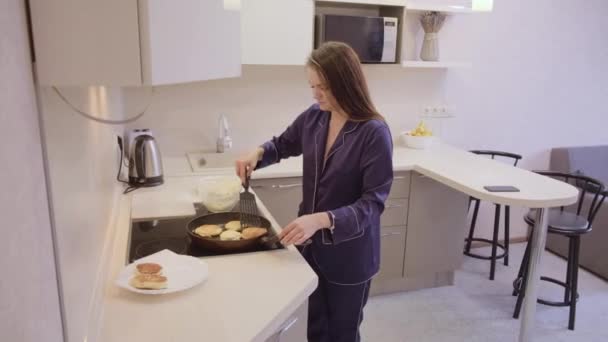 在公寓厨房里 一头乌黑的长发 身穿蓝色衣服的女孩在锅里烤着一顿丰盛的早餐 — 图库视频影像